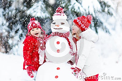 Kids building snowman. Children in snow. Winter fun. Stock Photo