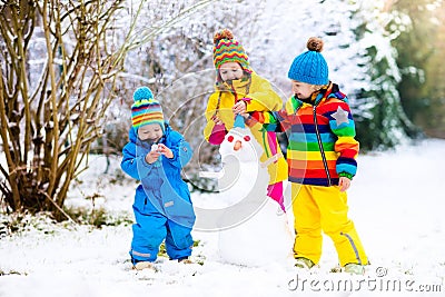 Kids building snowman. Children in snow. Winter fun. Stock Photo