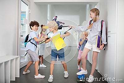 Children bullying poor boy while taking his backpack and pushing Stock Photo