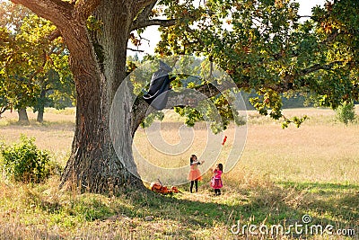 Children catch candy, which is teased by a reaper in a raincoat Stock Photo