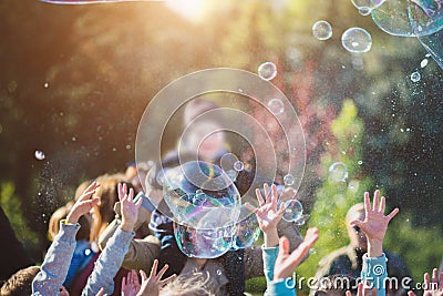 Children catch soap bubbles with their hands at a street party Stock Photo