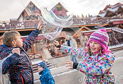 Children catching giant soap bubbles Editorial Stock Photo