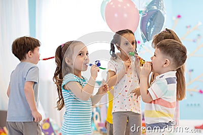 Children celebrating birthday party with noisemakers Stock Photo