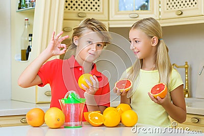 Children with citrus. boy showing ok close girl Stock Photo