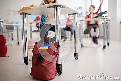 Children in classrom, detail on backpack of Ukrainian student, concept of enrolling Ukrainian kids to schools. Stock Photo