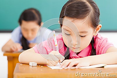 Children in classroom with pen in hand Stock Photo