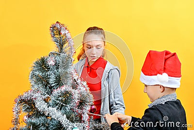 Children decorate the Christmas tree with various toys for the holiday Stock Photo