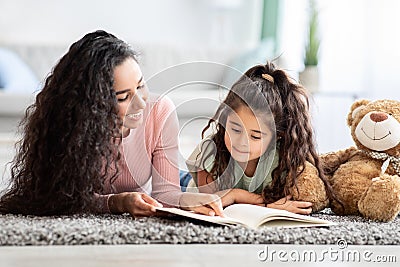 Children Development Concept. Loving Young Mom Reading Book To Her Little Daughter Stock Photo