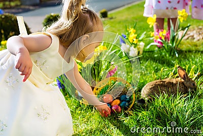 Children on Easter egg hunt with bunny Stock Photo