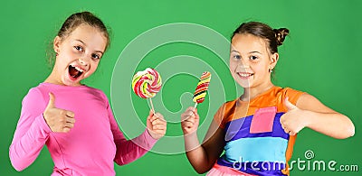 Children eat big colorful sweet caramels. Sisters with lollipops Stock Photo