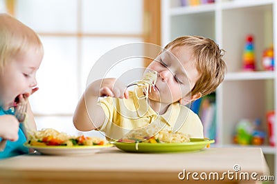 Children eating healthy food in kindergarten or Stock Photo