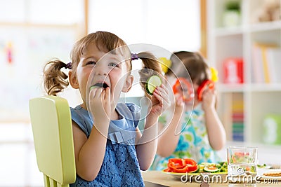 Children eating vegetables in kindergarten or at home Stock Photo