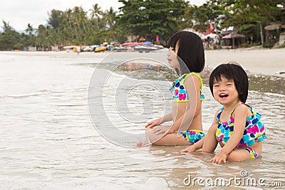 Children enjoy waves on beach Stock Photo