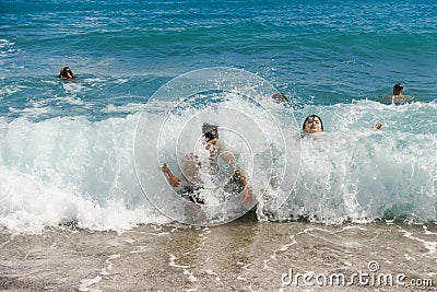 Children enjoying the wave splashes at the beach Stock Photo