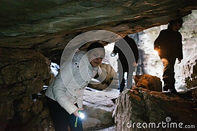 Children explore an underground cave with pile, adventurously Stock Photo