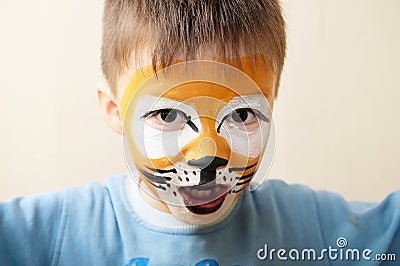 Children face painting. Boy painted as tiger or ferocious lion by make up artist. Preparing for theatrical performance Stock Photo