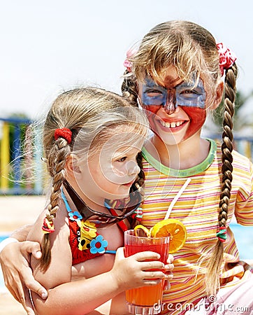 Children with face painting drinking juice. Stock Photo