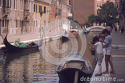 Children fishing in canal in Venice Editorial Stock Photo