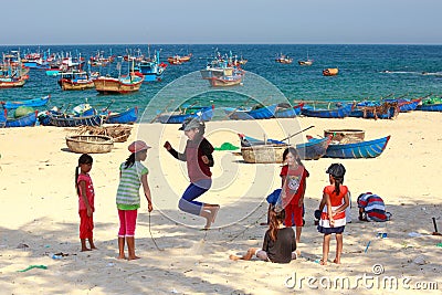 Children of fishing village playing jump rope on the sandy coast Editorial Stock Photo