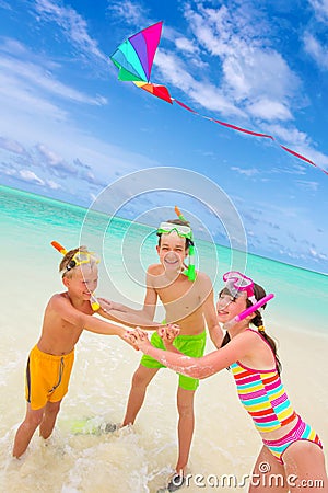 Children flying kite in sea Stock Photo