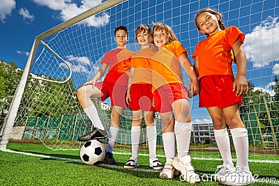 Children with football in a row near woodwork Stock Photo
