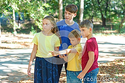 Children in the forest use a compass to study the direction of movement. The concept of children and adolescents outdoor Stock Photo