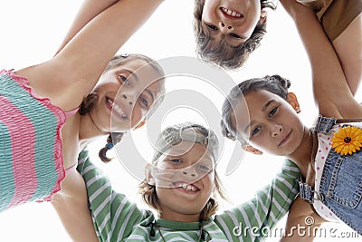 Children Forming Huddle Against Sky Stock Photo