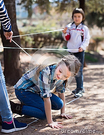 Children games. Girl goes through the tangled rope Stock Photo