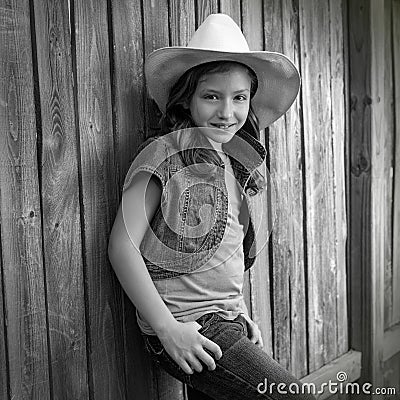 Children girl as kid cowgirl posing on wooden fence Stock Photo