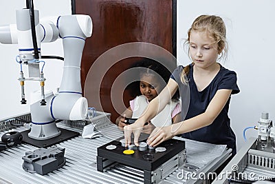 Children girl caucasoid and girl African American education electronic robotic arm on table at class room. learning innovation Stock Photo