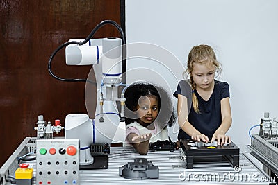 Children girl caucasoid and girl African American education electronic robotic arm on table at class room. learning innovation Stock Photo