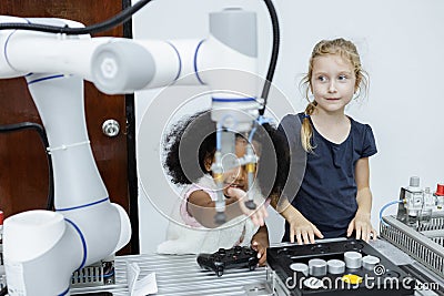 Children girl caucasoid and girl African American education electronic robotic arm on table at class room. learning innovation Stock Photo