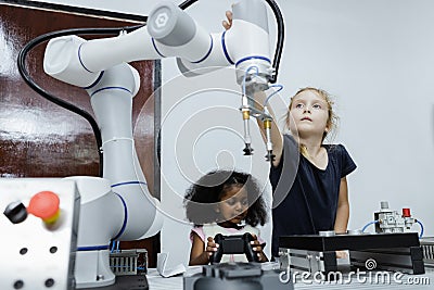 Children girl caucasoid and girl African American education electronic robotic arm on table at class room. learning innovation Stock Photo