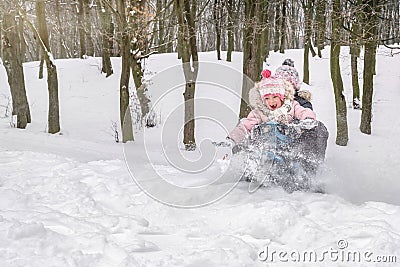 Children going sledging in a city park in a winter snowy day Stock Photo