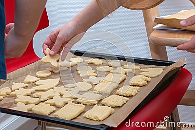 Children hand laying cookie on a baking tray Stock Photo