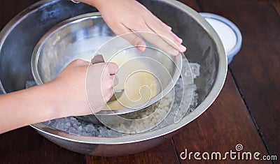 Children hand making home made ice cream with iced bowl. Stock Photo