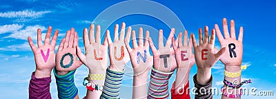 Children Hands Building Word Volunteer, Blue Sky Stock Photo