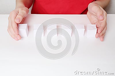 Children hands and row of six small paper cubes Stock Photo