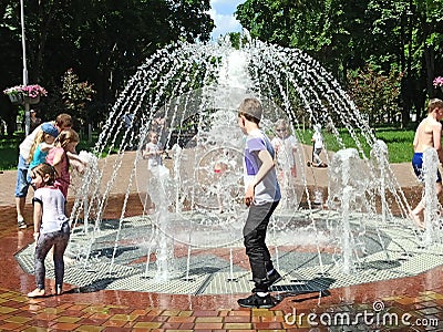 Children have a fun with city fountains in hot summer day Editorial Stock Photo