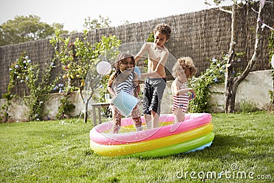 Children Having Fun In Garden Paddling Pool Stock Photo