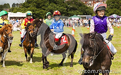 Children heading towards the starting line on their shetland ponies for Grand National qualifier Editorial Stock Photo