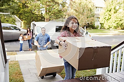 Children Helping Unload Boxes From Van On Family Moving In Day Stock Photo