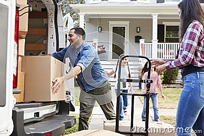 Children Helping Unload Boxes From Van On Family Moving In Day Stock Photo