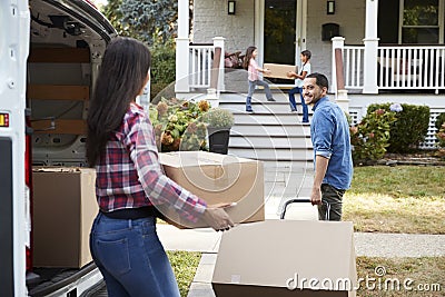 Children Helping Unload Boxes From Van On Family Moving In Day Stock Photo