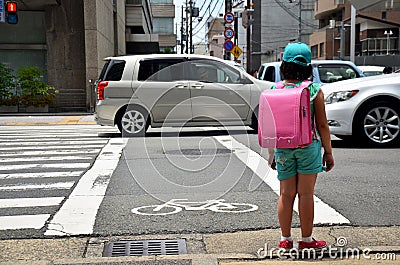 Children japanese girl waiting cross over road at crosswalk traffic road after finished study class at school near Gojo subway st Editorial Stock Photo