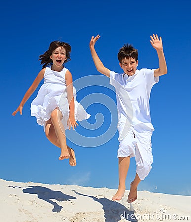 Children jumping on beach Stock Photo