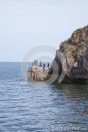 Children jumping into the sea at Babbacombe Beach in Torbay, Devon in the UK Editorial Stock Photo