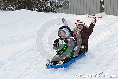 Children kids sledding toboggan sled snow winter Stock Photo