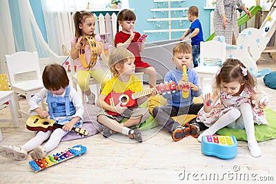 Children learning musical instruments on lesson in kindergarten or preschool Stock Photo