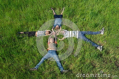 Children lying on the grass, happy and joyful brothers and sisters, top view Stock Photo